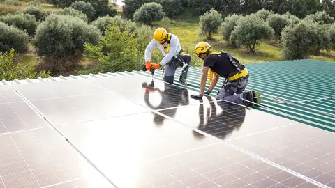 Dos trabajadores de SotySolar instalando paneles.